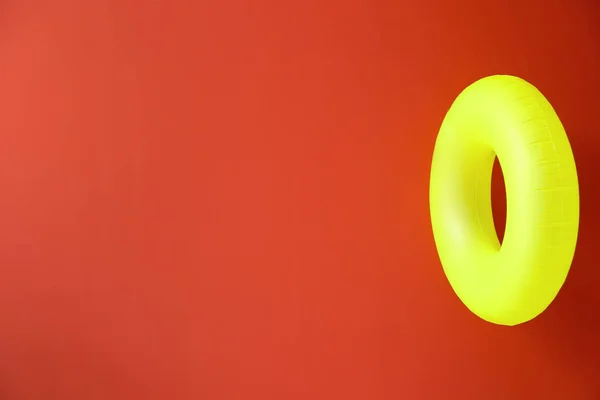 Bright inflatable ring on color background