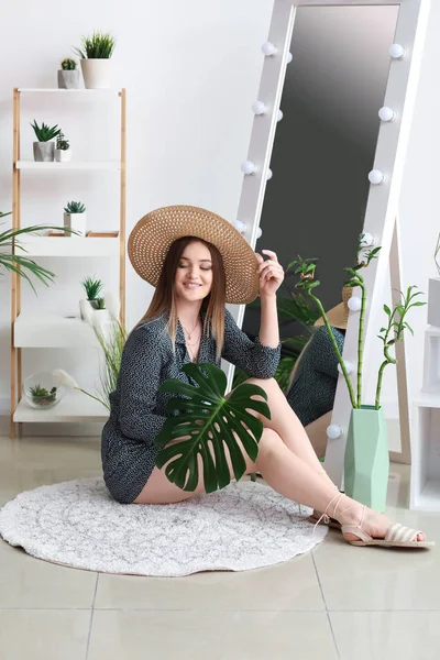 Портрет красивой женщины с зеленым тропическим листом в помещении — стоковое фото