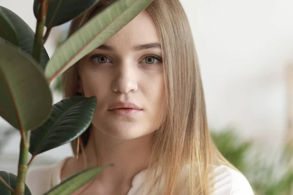 Портрет красивой женщины с зеленым тропическим растением — стоковое фото