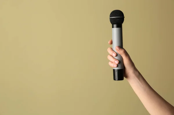Female hand with microphone on color background — Stock Photo, Image