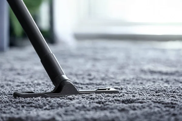 Escova de aspirador de pó no tapete no quarto — Fotografia de Stock