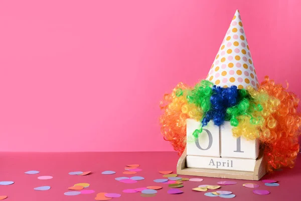 Party decor with calendar on color background. April Fool\'s Day celebration