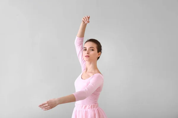 Mooie jonge ballerina op lichte achtergrond — Stockfoto