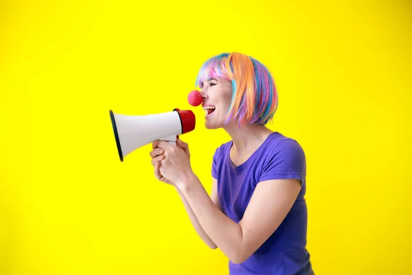 Funny woman with megaphone on color background. April Fools' Day prank — Stock Photo, Image