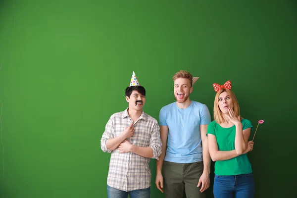 Funny friends with party decor for April Fools' Day on color background — Stock Photo, Image