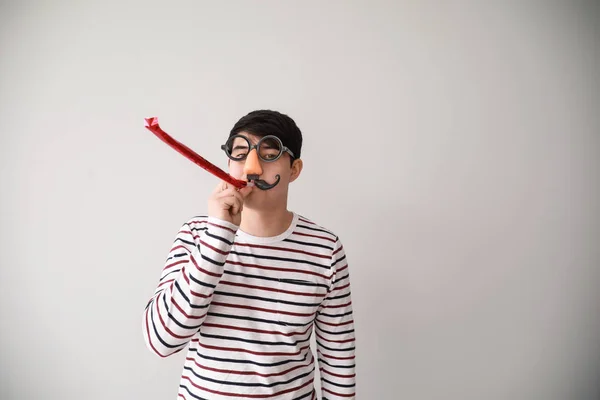 Funny Asian man met partij fluit voor april Fools ' dag prank op lichte achtergrond — Stockfoto