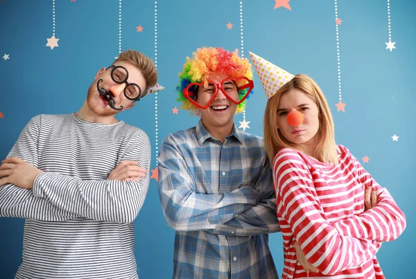 Funny friends with party decor for April Fools' Day on color background — Stock Photo, Image