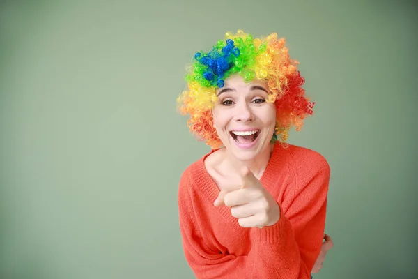 Grappige vrouw met pruik voor april Fools ' dag viering op kleur achtergrond — Stockfoto