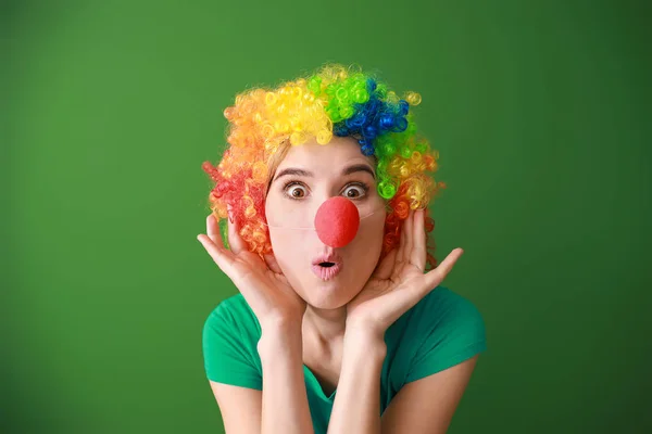 Legrační žena s dekoracemi pro duben bláznů na barevném pozadí — Stock fotografie