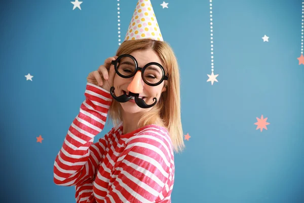Funny woman with party decor for April Fools' Day on color background — Stock Photo, Image