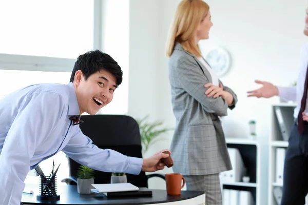 Asian man playing a prank on his colleague in office. April Fools' Day prank — Stock Photo, Image