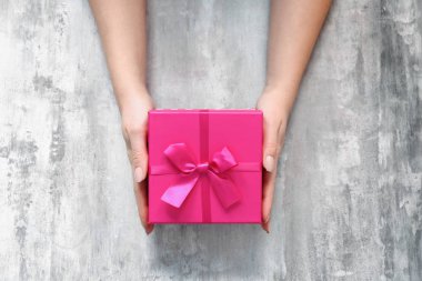 Grunge arka planda hediye kutusu ile kadın eller