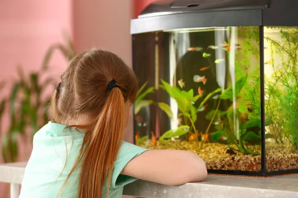 Schattig klein meisje te kijken naar vis in het aquarium — Stockfoto