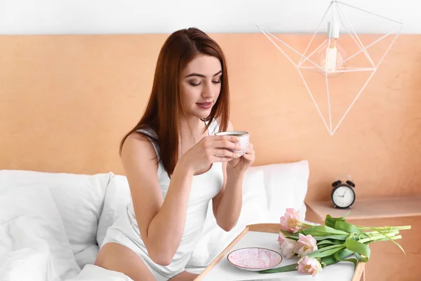 Morning of beautiful young woman drinking coffee in bed — Stock Photo, Image