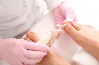 Podiatrist Spa salonunda genç kadının ayakları soyma