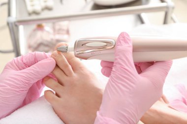 Podiatrist Spa salonunda genç kadının ayakları soyma