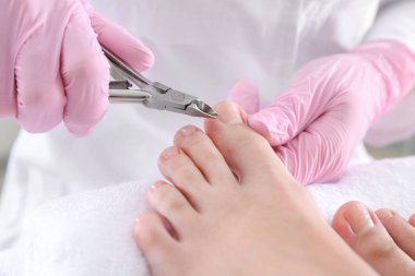 Podiatrist Spa salonunda genç kadının ayaklar kapalı sert cilt kesme