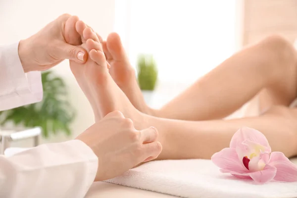 Jovem mulher recebendo massagem nos pés no salão de spa — Fotografia de Stock