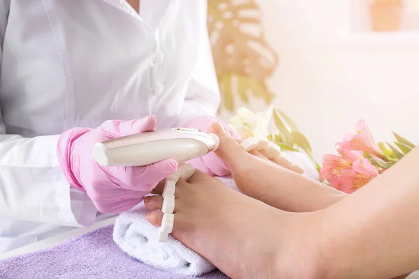 Podiatrist peeling stóp młodej kobiety w salonie Spa — Zdjęcie stockowe