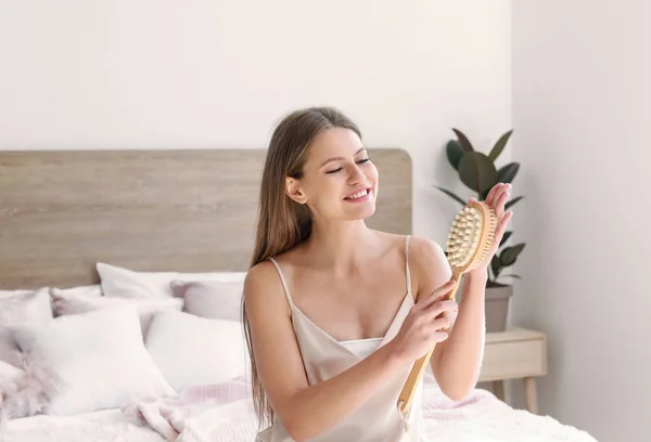 Mulher bonita com escova de massagem no quarto — Fotografia de Stock