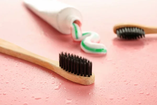 Pasta de dentes com escovas no fundo de cor — Fotografia de Stock