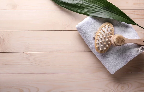 Cepillos de masaje con toalla sobre mesa de madera — Foto de Stock