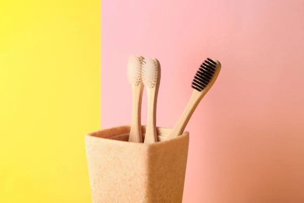 Holder with toothbrushes on color background — Stock Photo, Image