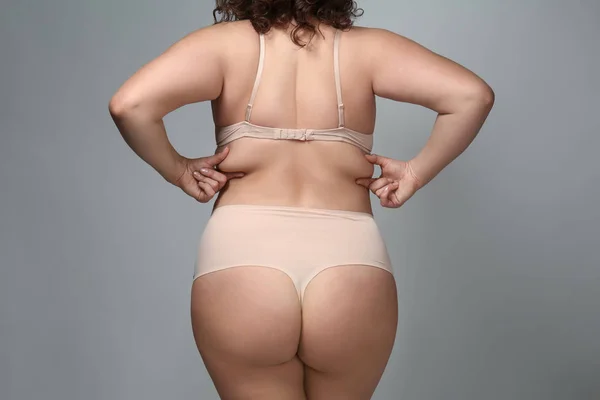 Nadváha žena na šedém pozadí — Stock fotografie