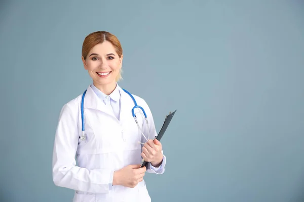 Portrait of beautiful gynecologist on grey background — Stock Photo, Image