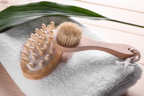 Massage brushes with towel on wooden table — Stock Photo, Image