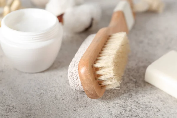 Massage brush with cosmetics on grey background — Stock Photo, Image