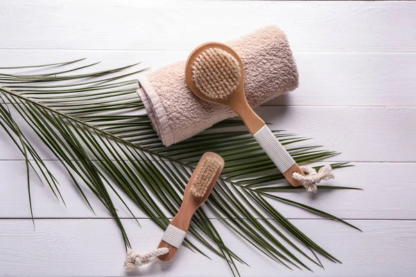 Massage brushes with towel on white wooden table — Stock Photo, Image