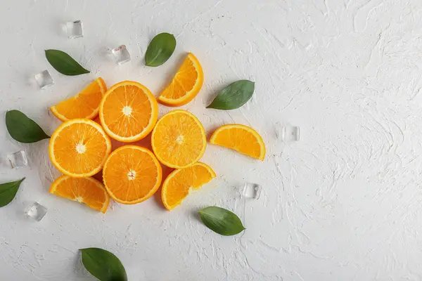 Composition with cut oranges and ice cubes on white background — Stock Photo, Image