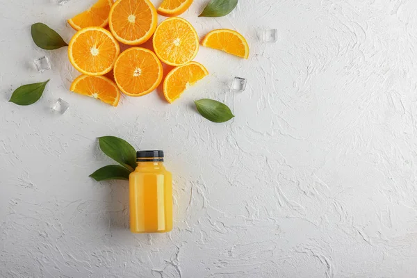 Şişe taze meyve suyu ve beyaz zemin üzerine kesilmiş portakal