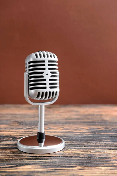 Retro microphone on table against color background — Stock Photo, Image