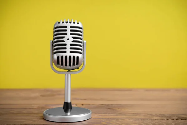 Retro microphone on table against color background — Stock Photo, Image