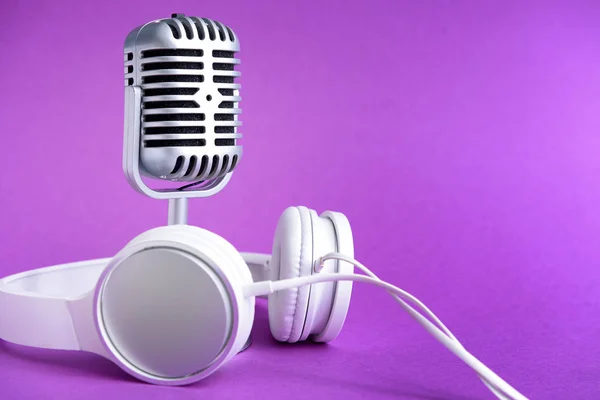 Retro microphone and headphones on color background — Stock Photo, Image