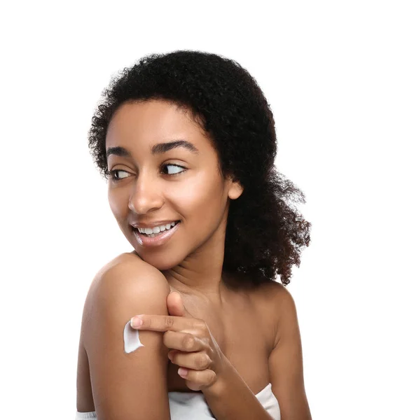 Unga afroamerikanska kvinnan tillämpa kroppskräm som mot vit bakgrund — Stockfoto