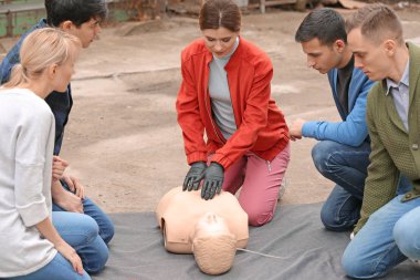 CPR ilk yardım eğitim kursu, manken üzerinde gösteren eğitmen