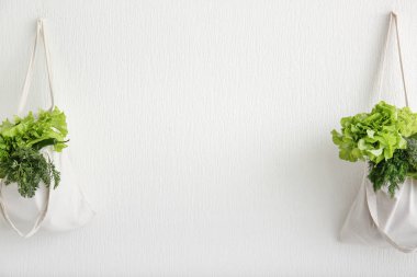 Eco torbaları ile taze sebze duvarda asılı