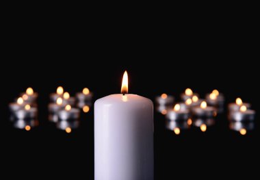 Burning candles on black background clipart