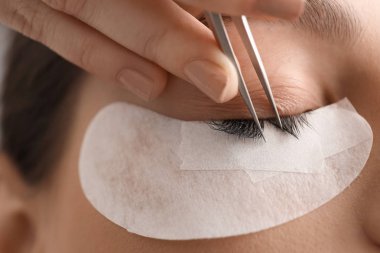 Güzellik salonunda kirpik uzatma prosedürüne tabi tutulan genç bir kadın.