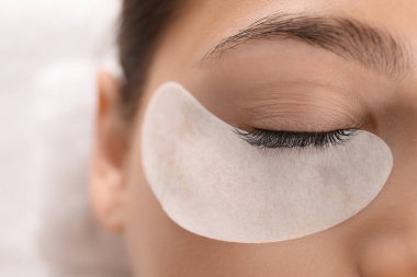 Güzellik salonunda kirpik uzatma prosedürüne tabi tutulan genç bir kadın.