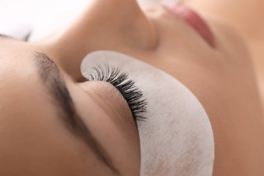 Güzellik salonunda kirpik uzatma prosedürüne tabi tutulan genç bir kadın.
