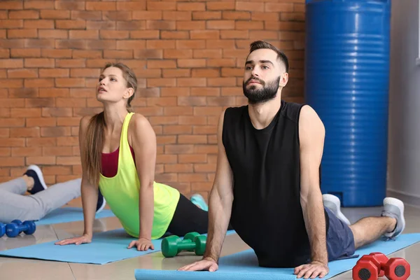 Sporty young people training in gym — Stock Photo, Image