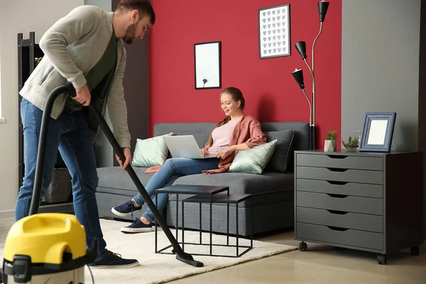 Ama de casa limpiando el piso mientras su esposa trabaja en casa —  Fotos de Stock