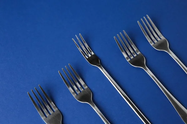 Forks on color background. Concept of uniqueness — Stock Photo, Image