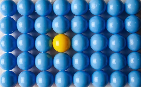 Κίτρινη μπάλα ανάμεσα σε μπλε, κορυφαία θέα. Έννοια της μοναδικότητας — Φωτογραφία Αρχείου