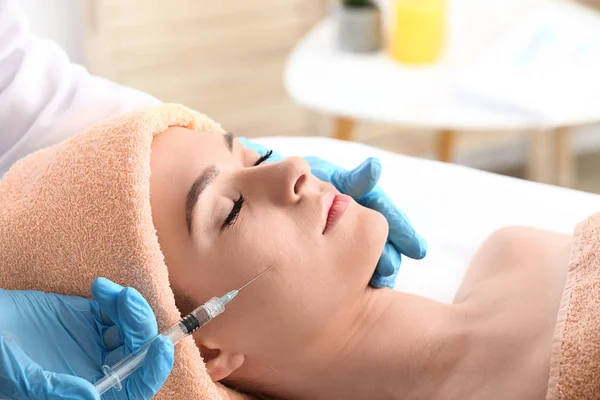 Young woman receiving filler injection in beauty salon — Stock Photo, Image