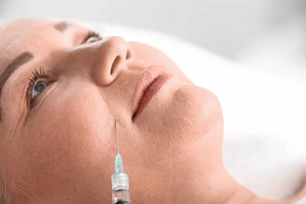 Mature woman receiving filler injection in beauty salon, closeup — Stock Photo, Image